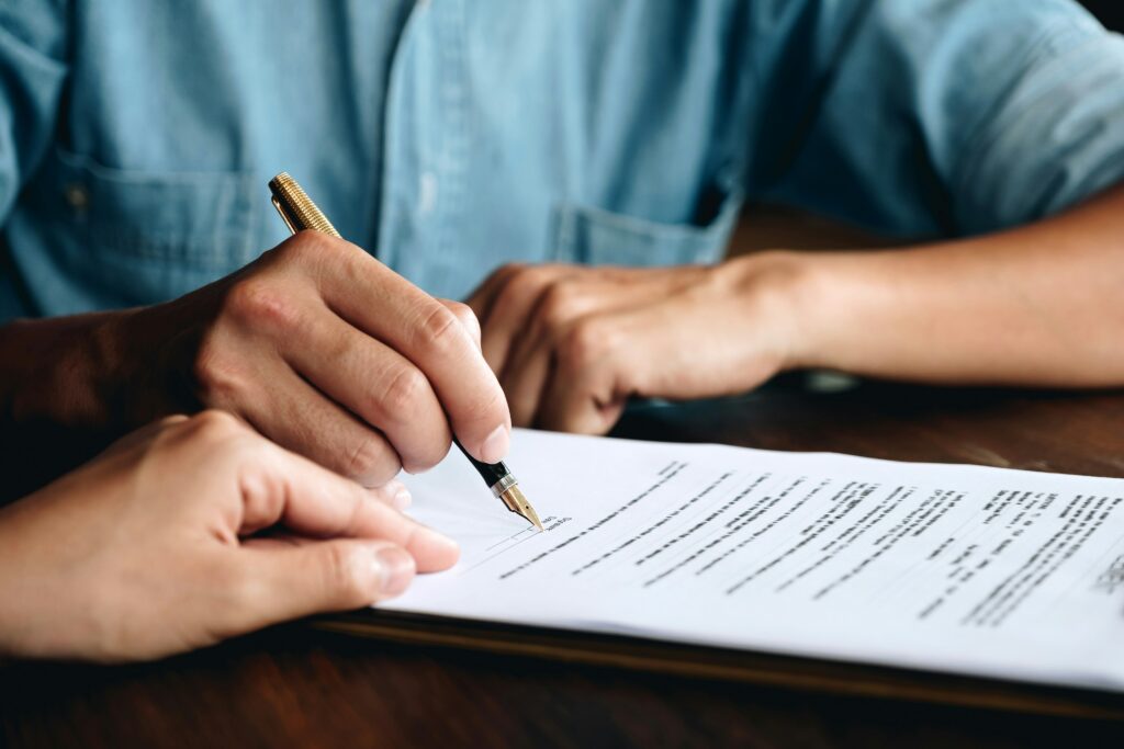 Man signing a contract with a woman at a table, both engaged in a professional discussion.