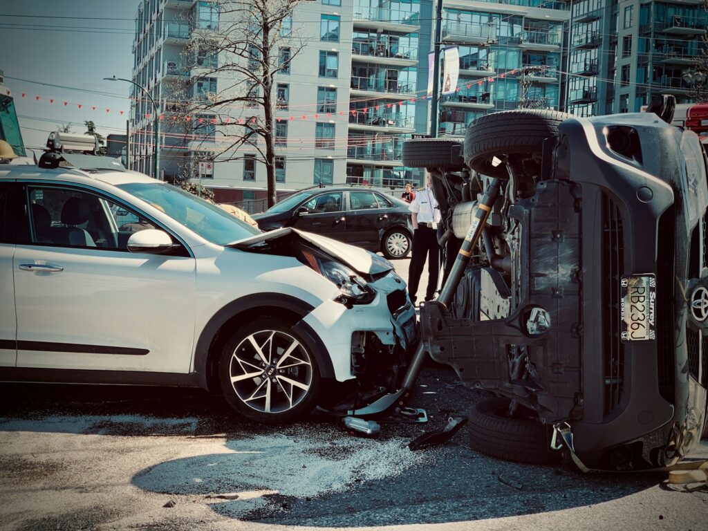 A car with significant damage from a collision, showing crumpled metal and shattered glass on the driver's side.