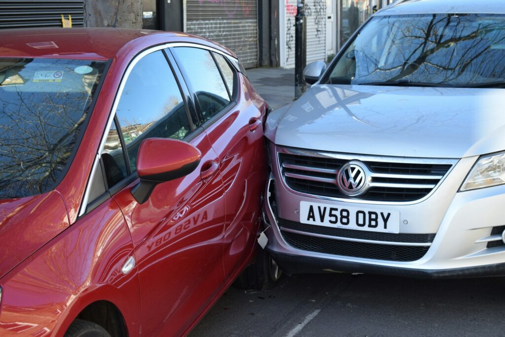 A car is parked beside a white van in a parking area.